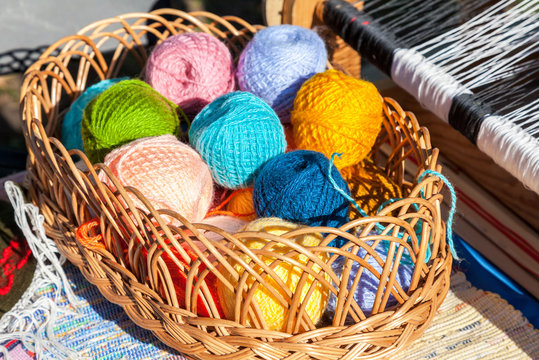 Bright multi-colored balls of yarn in wicker basket