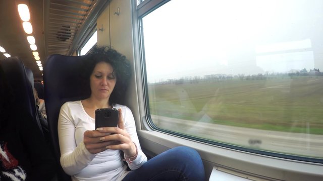 4k Smart phone girl watching funny video laughing while traveling in train. Using smartphone commuting in public transportation. UHD stock footaga