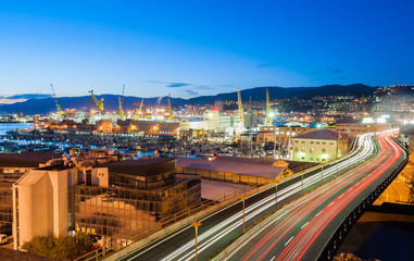 Fototapeta premium Traffic in a street of Genoa during the twilight