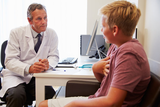 Teenage Boy Having Consultation With Doctor In Office