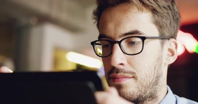 Happy young man using digital tablet ipad computer in cafe