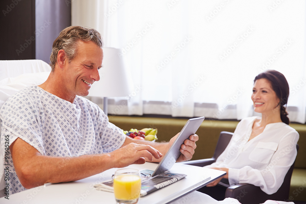 Wall mural Male Patient In Hospital Bed Using Digital Tablet