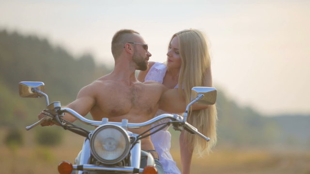 Man and woman on a motorcycle outdoors.