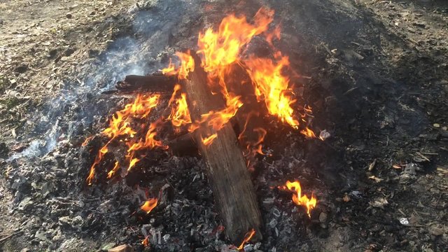 wooden planks burning in huge bonfire on the charcoal heap