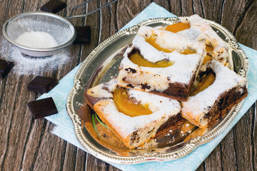 Homemade chocolate marble cake with peaches on a wooden table