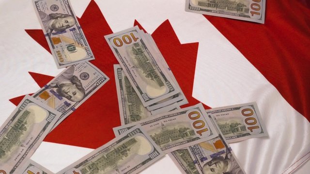 Falling hundred dollar bills on the canadian flag