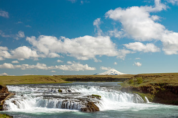 Small waterfall in Iceland with Hekla Volcano in the back