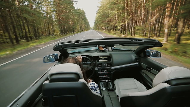 Female driving a luxury open top car