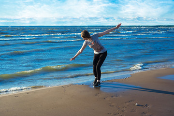 Fototapeta na wymiar Happy young woman standing on the beach