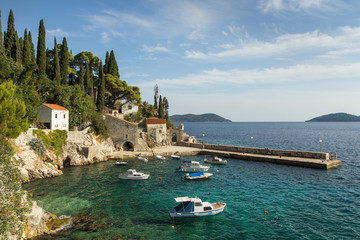 Picturesque view of a port with few boats and old buildings at a small town Trsteno in Croatia.