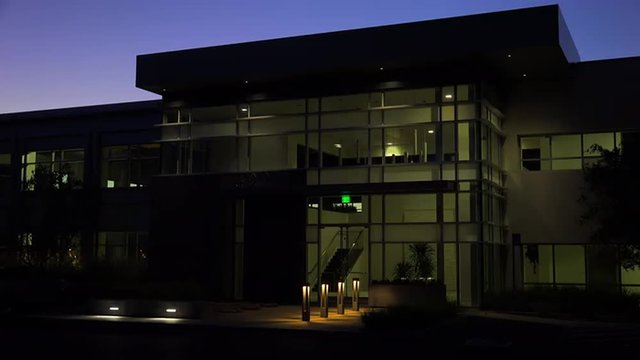 Establishing shot of the exterior of a generic modern office building at night.