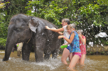 Children bathing a baby elephant in Asia