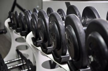 Obraz na płótnie Canvas Weights, many black dumbbell in fitness room.
