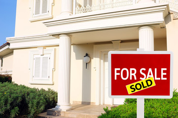 Real estate sign in front of new house for sale