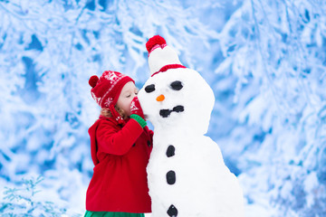 Little girl building a snow man