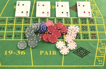 Deck of cards with pieces of poker on green carpet