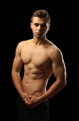 Fototapeta premium Muscle young man on dark background