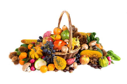 Autumn harvest - fresh autumn fruits and vegetables in wicker basket on white background