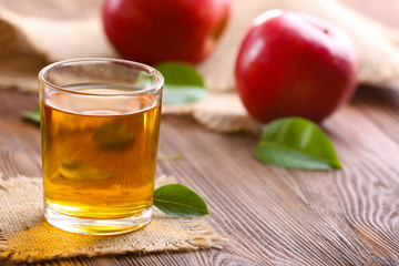Glass of apple juice and fruits on table close up