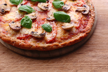 Tasty pizza with vegetables and basil on table close up