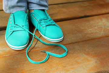 Female feet in gum shoes on wooden floor background