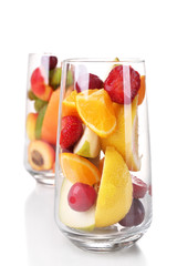 Fresh fruits salad in glasses isolated on white