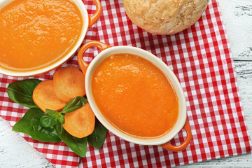 Carrot cream-soup with buns on table close up