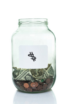 Glass jar with a white dollar sign label and some money in it