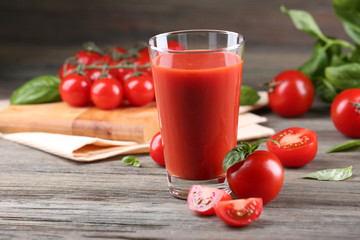 Glass of tomato juice with vegetables on wooden table close up