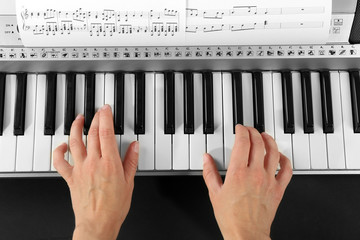 Woman playing synthesizer close up