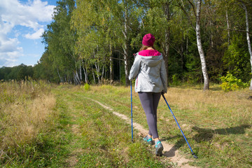 Young woman goes Nordic walking