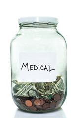Glass jar with with a white medical label and some money in it