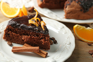 Cake with Chocolate Glaze and orange on plate, on wooden background