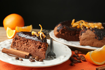 Cake with Chocolate Glaze and orange on plate, on wooden table, on dark  background