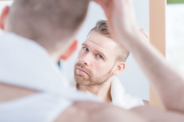 Handsome man watching himself