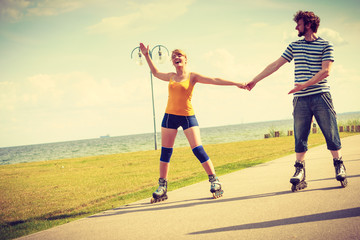 Young couple on roller skates riding outdoors
