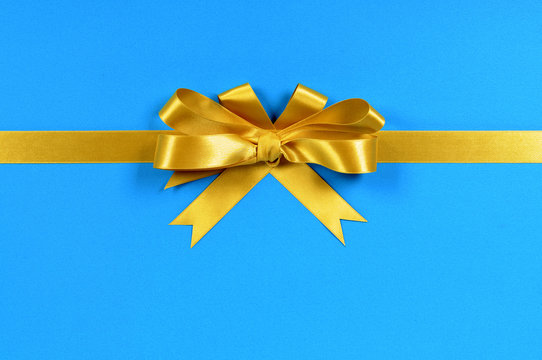 Gold Gift Bow And Ribbon Straight Horizontal Banner For Christmas Or Birthday Present On A Blue Wrapping Paper Background Photo