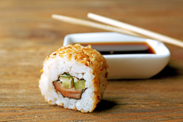 Roll with sauce and sticks on wooden table close up