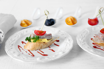 Tasty canapes on wooden table, close up