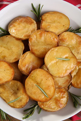 Delicious baked potato with rosemary in bowl close up