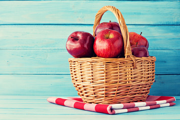 Red apples in a basket over turquoise wood