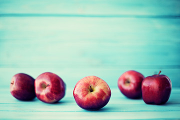 Red apples over turquoise wood