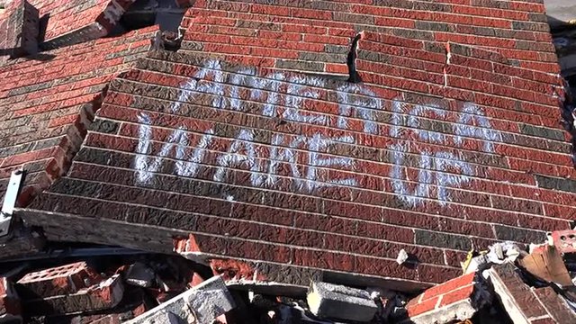 Graffiti on a ruined building following the Ferguson rioting urges America to wake up.