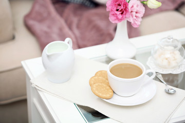 Cup of coffee on table in living room