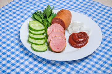 Сарделька с овощами на тарелке