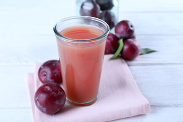 Delicious plum juice with fruits on wooden table close up