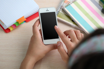 Woman using mobile phone on workplace close up