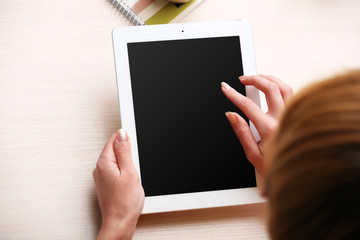 Woman using digital tablet on workplace close up