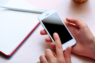 Woman using mobile phone on workplace close up