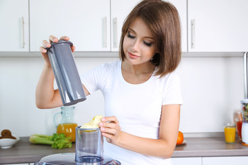 Young beautiful woman using juicer, preparing  fresh juice